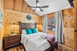 a bedroom with a bed and a ceiling fan at The Family Stone Luxe Cabin Sleeps 12 Hot tub Dogfriendly Dollywood in Pigeon Forge