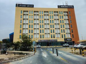 un grand bâtiment jaune avec une rue en face dans l'établissement JOIN INN HOTEL Jebel Ali, Dubai - Formerly easyHotel Jebel Ali, à Dubaï