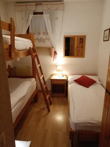 a small room with two bunk beds and a desk at Ski-Garden in Mezzana