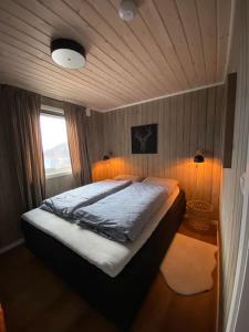 a bedroom with a bed and a window and lights at Hytte i Neverfjord. in Kvalsund