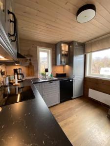 a kitchen with a black counter top in a room at Hytte i Neverfjord. in Kvalsund