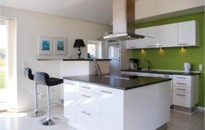 Spodsbjergにある4 Bedroom Beautiful Home In Rudkbingのキッチン(白いキャビネット、黒いカウンタートップ付)
