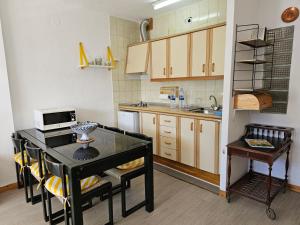 una pequeña cocina con mesa y fregadero en Agradable apartamento familiar, en Sierra Nevada