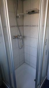 a shower with a glass door in a bathroom at Ferienwohnung Käfer in Rust