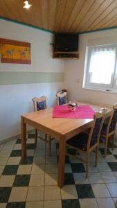a dining room table with chairs and a pink napkin on it at Ferienwohnung Käfer in Rust