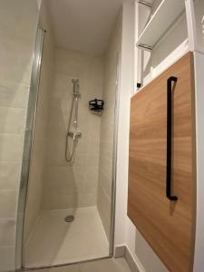 a shower with a glass door in a bathroom at Studio des Pins neuf avec son garage fermé et son balcon in Villeneuve-lès-Maguelonne