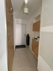 a hallway of a kitchen with a white floor and a door at Studio des Pins neuf avec son garage fermé et son balcon in Villeneuve-lès-Maguelonne