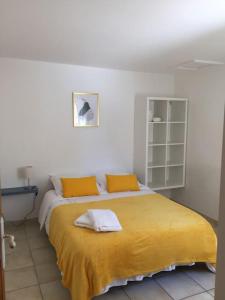 a bedroom with a large bed with yellow sheets at Jolie maison de ville au calme in Châteauneuf-lès-Martigues