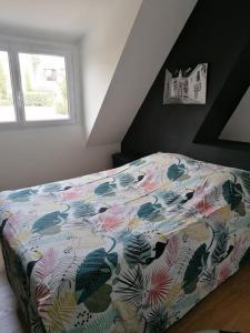 a bedroom with a bed with a floral comforter at Saint Malo Agréable maison familiale in Saint Malo