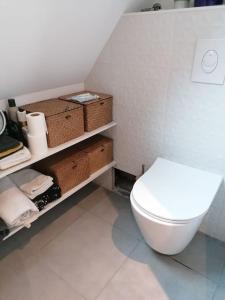 a bathroom with a white toilet and some baskets at Saint Malo Agréable maison familiale in Saint Malo