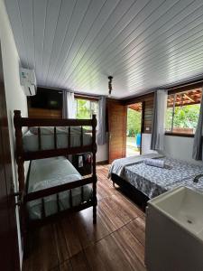 a bedroom with two bunk beds and a tub at Suíte - Pousada Sul da Ilha in Ilha do Mel