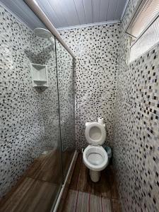 a bathroom with a toilet and a shower at Suíte - Pousada Sul da Ilha in Ilha do Mel