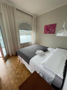 sypialnia z dużym łóżkiem i oknem w obiekcie CASA DEL LAGO w mieście Omegna