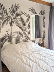 1 dormitorio con 1 cama con un mural de palmeras en Maison de ville à 5mn de la plage-jardin clos proche plage en Planguenoual