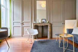 salon z kanapą i kominkiem w obiekcie Charmant appartement central w Lille