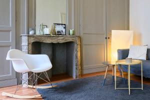 salon z kominkiem i białym krzesłem w obiekcie Charmant appartement central w Lille