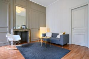 salon z niebieską kanapą i kominkiem w obiekcie Charmant appartement central w Lille
