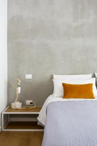 a bed with an orange pillow on a table at Canceddi Rooms in Palermo