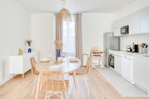 Una cocina y un comedor con mesa y sillas. en Appartement Aigrette - La Maison Heureuse - Welkeys, en Saint-Georges-dʼOléron