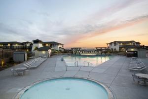 a large swimming pool with chairs and a sunset at Sanctuary Beach Resort in Marina