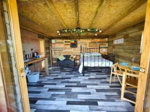 Zimmer mit einem Bett und einem Tisch in der Unterkunft Little Swelle Cabin with awesome Sea views in Poundstock