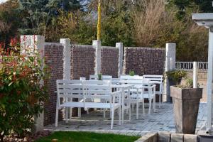 een rij witte tafels en stoelen in een tuin bij Gästehaus Luna in Rust