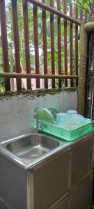 eine Küchenspüle mit einem Tablett darüber in der Unterkunft Bamboo Garden Tourist Inn in Carmen
