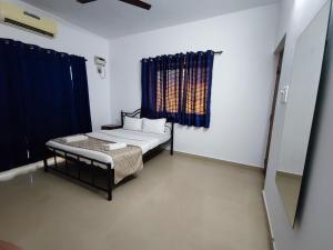 um pequeno quarto com uma cama e uma janela em Maria Comfort Stay em Calangute