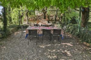 een tafel en stoelen onder een boom bij Villa Casanova in Cerbaiolo