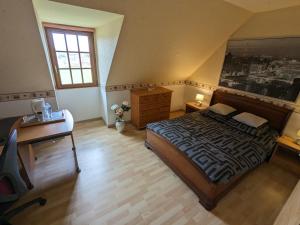 a bedroom with a bed and a desk and a window at CYGNE-CYCLES chambre d'hotes 