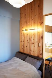 a bedroom with a bed and a wooden wall at Shibuya apartment SHINSEN in Tokyo