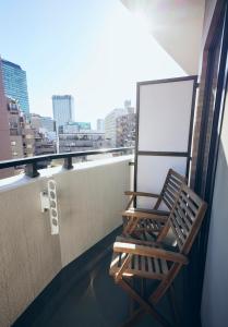a chair on a balcony with a view of a city at Shibuya apartment SHINSEN in Tokyo