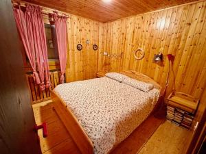 a bedroom with a bed in a wooden room at Tormentina - Piancavallo in Piancavallo