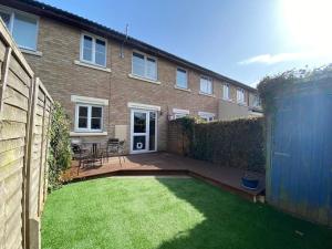 a backyard of a house with a grass yard at 2 Bed House in Hampton - Free parking in Hanworth