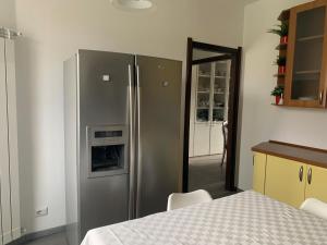 eine Küche mit einem Kühlschrank aus Edelstahl und einem Tisch in der Unterkunft Casa Carlotta - Milan Expo in Arese