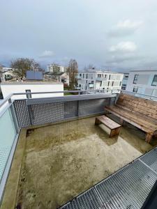 einen Balkon mit einer Holzbank und einem Holztisch in der Unterkunft Wohnung Nähe Flughafen und Messe in Düsseldorf