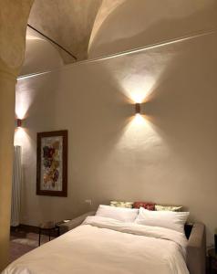 sypialnia z łóżkiem z dwoma światłami na ścianie w obiekcie Appartamento L'antica colonna, in centro storico w mieście Parma