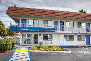 a building with a welcome sign in a parking lot at Motel 6-Vacaville, CA in Vacaville