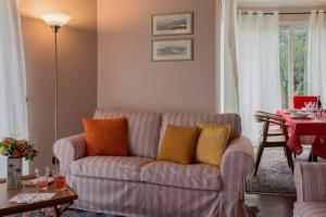 uma sala de estar com um sofá com almofadas coloridas em Villa Ametista em Meina