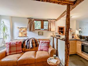 a living room with a brown couch in a kitchen at 1 Bed in Crosthwaite LCC70 in Crosthwaite