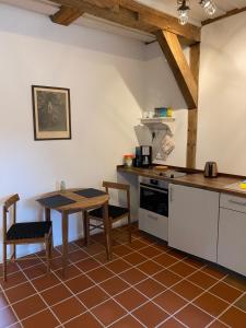 uma cozinha com uma mesa e uma mesa e cadeiras em Müllernhof em Faßberg