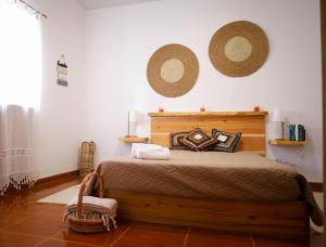 a bedroom with a bed with two hats on the wall at Beleza da Fazenda in Nordeste