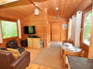 a living room of a log cabin with a television at 1 Bed in Dulverton WONLO in Bampton