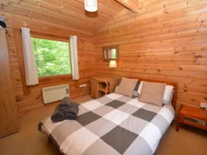 a bedroom with a bed in a log cabin at 1 Bed in Dulverton WONLO in Bampton