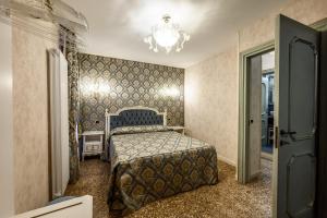 a bedroom with a bed and a chandelier at Cà Rialto 4122 Luxury Terrace in Venice