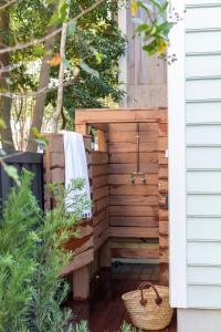 eine Außendusche mit einem Handtuch an einer Holzwand in der Unterkunft Green Cottage at Casa Zoe in Charleston