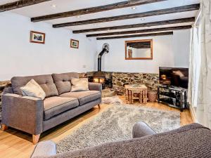 a living room with a couch and a fireplace at 1 Bed in Great Torrington ANNAS in Langtree