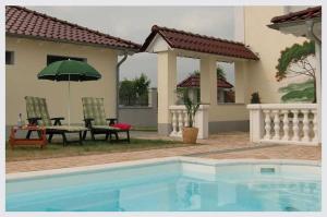 a house with a pool and a table and an umbrella at Pummpälzhof in Bad Salzungen