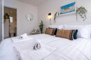 1 dormitorio con 1 cama blanca grande y toallas. en Bright bold beautiful Close to Brighton station en Brighton & Hove