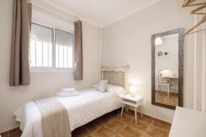una camera bianca con letto e specchio di Los Cármenes a Algeciras